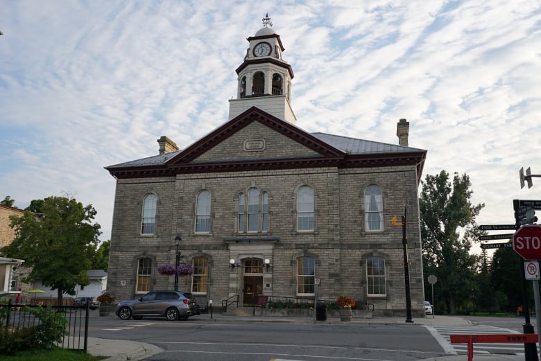 A photo of a stone building with a clock on top