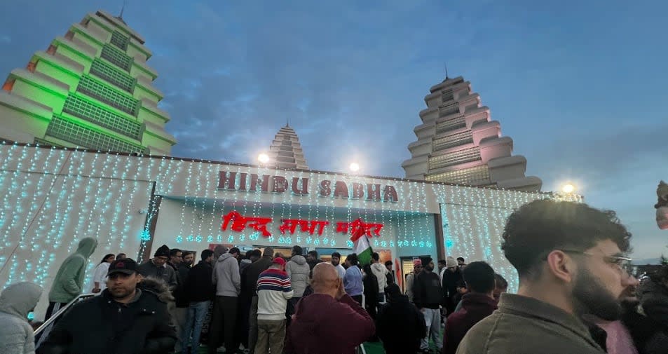 A crowd gathers outside Hindu Sabha Mandir temple Sunday evening, hours after a protest outside the temple prompted a police investigation.