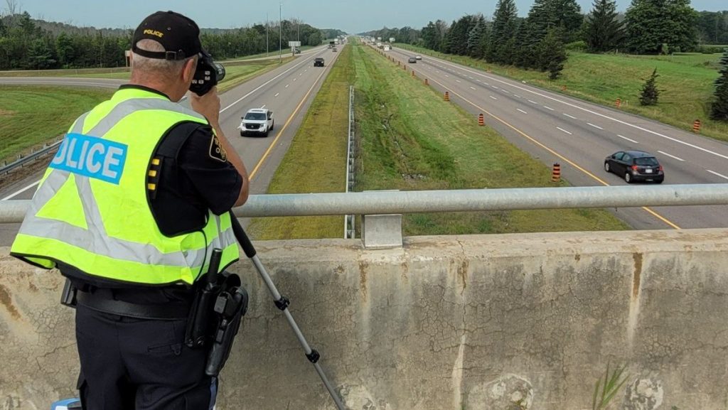 Ontario Provincial Police officer standing on an overpass in the East Region catching people speeding. (OPP)