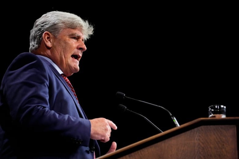 A politician speaks at a lectern while giving a news conference.