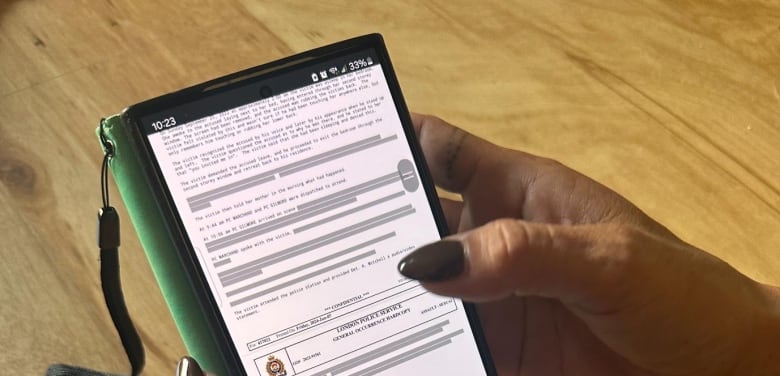 The mom of the 13-year-old girl reads a redacted police report on her phone. The documents were obtained through a freedom of information request. 