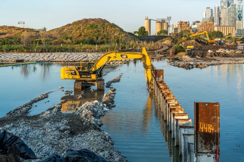 An excavator using a grinder attachment removing the north plug.