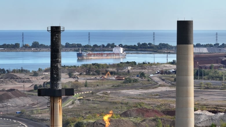 An aerial image of a factory showing two smokestacks in the foreground. 