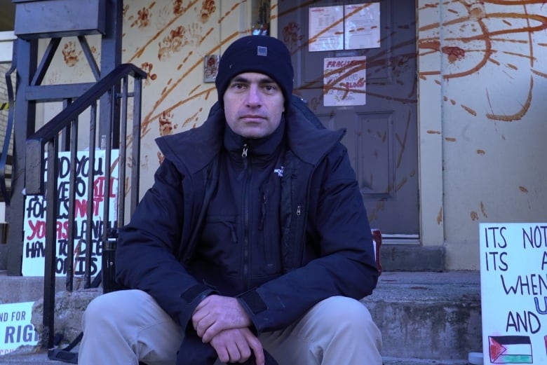 Dr. Tarek Loubani sits in front of London MP Peter Fragiskatos's office after telling CBC News he was responsible for covering it in ketchup just hours after his charges for the same offence were dropped.