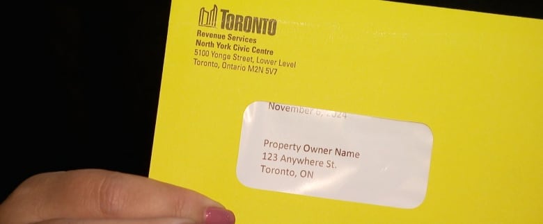 Woman holding a bright yellow envelope.