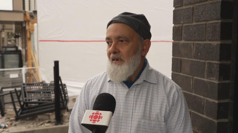 Photo of a man speaking outside his house