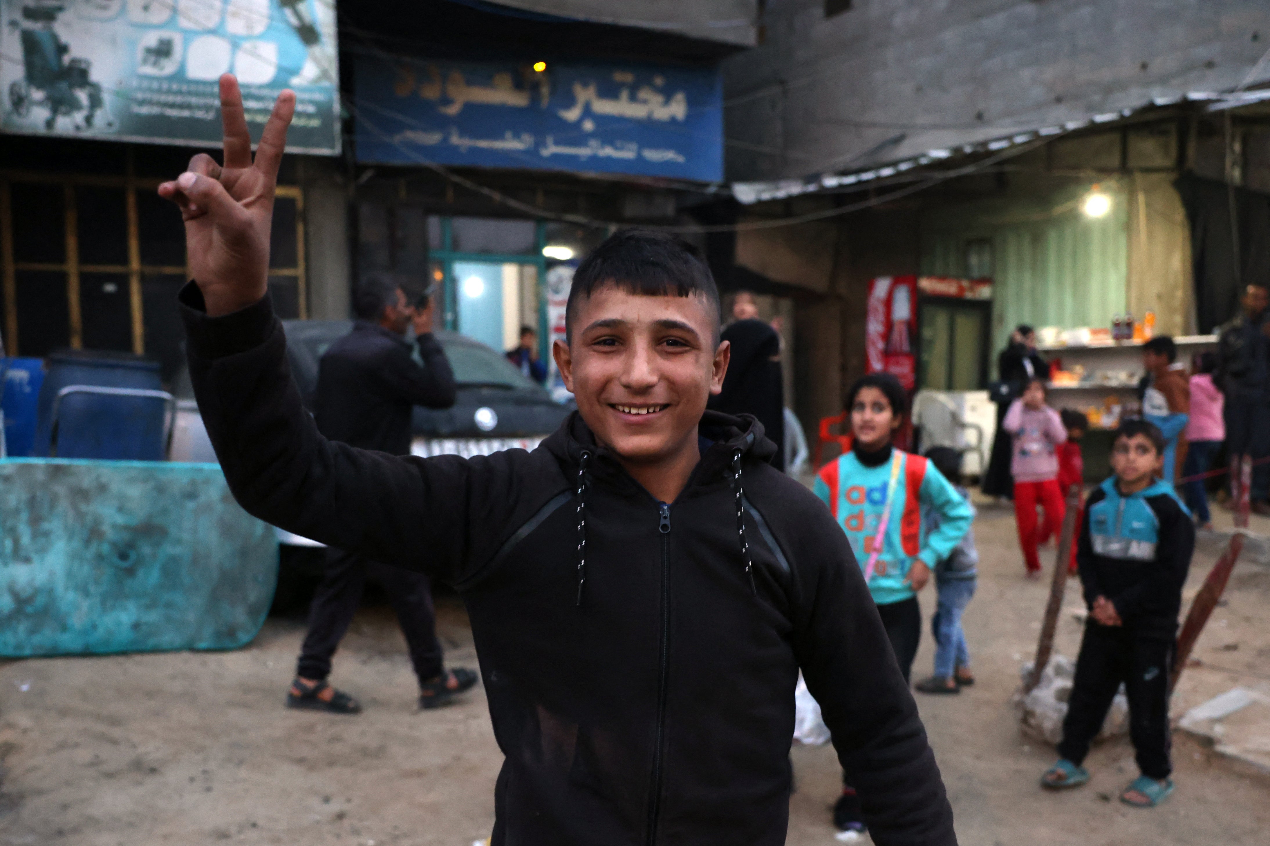A boy celebrates along a street in Khan Yunis in the southern Gaza Strip on January 15, 2025, amid the ongoing war in the Palestinian territory between Israel and Hamas.