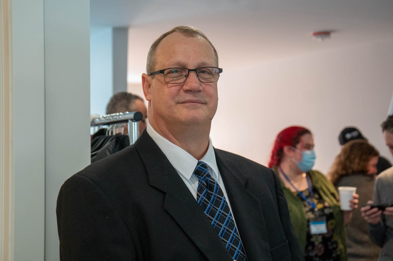 A person wearing a suit is seen standing in a home.