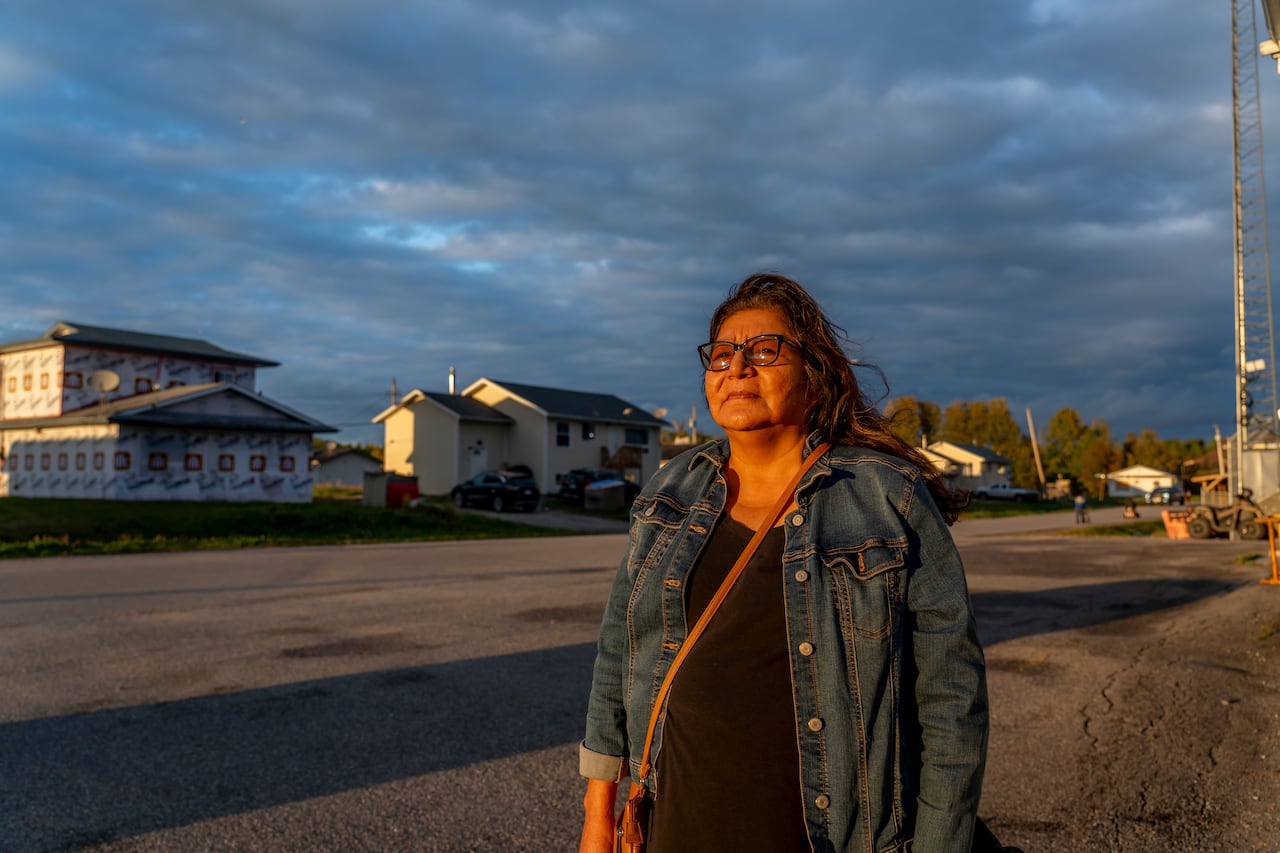 A person is seen standing on a street, staring into the sunset.