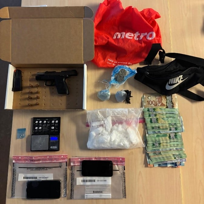 A photo of cash, drugs, a handgun and ammunition spread out on a wooden table.