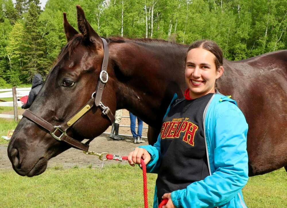OVC student Paris Fuzy poses next to a horse outdoors