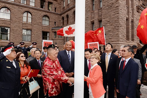 Toronto POlice Officer Peter Yuen appears to be saluting the China flag as it is being raised during a ceremony at Queen's Park.