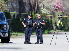 Two Sarnia police officers investigate a fatal crash