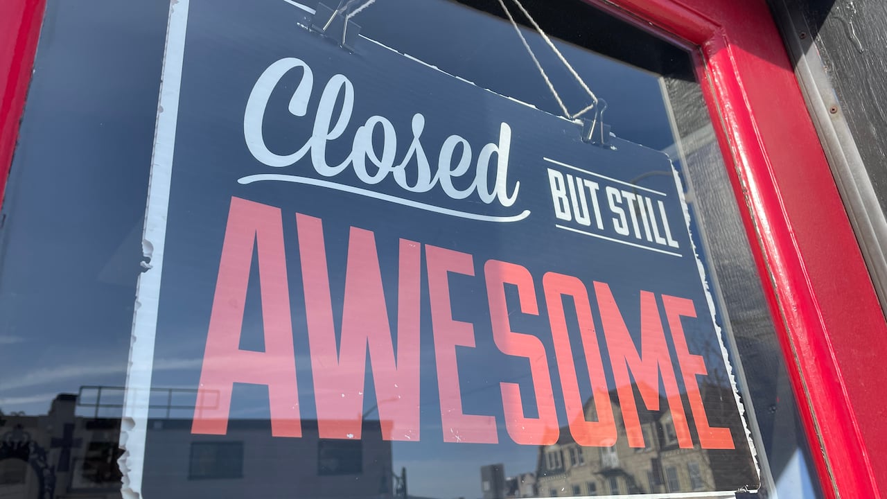 A closed sign in a business window that says " closed but still awesome."