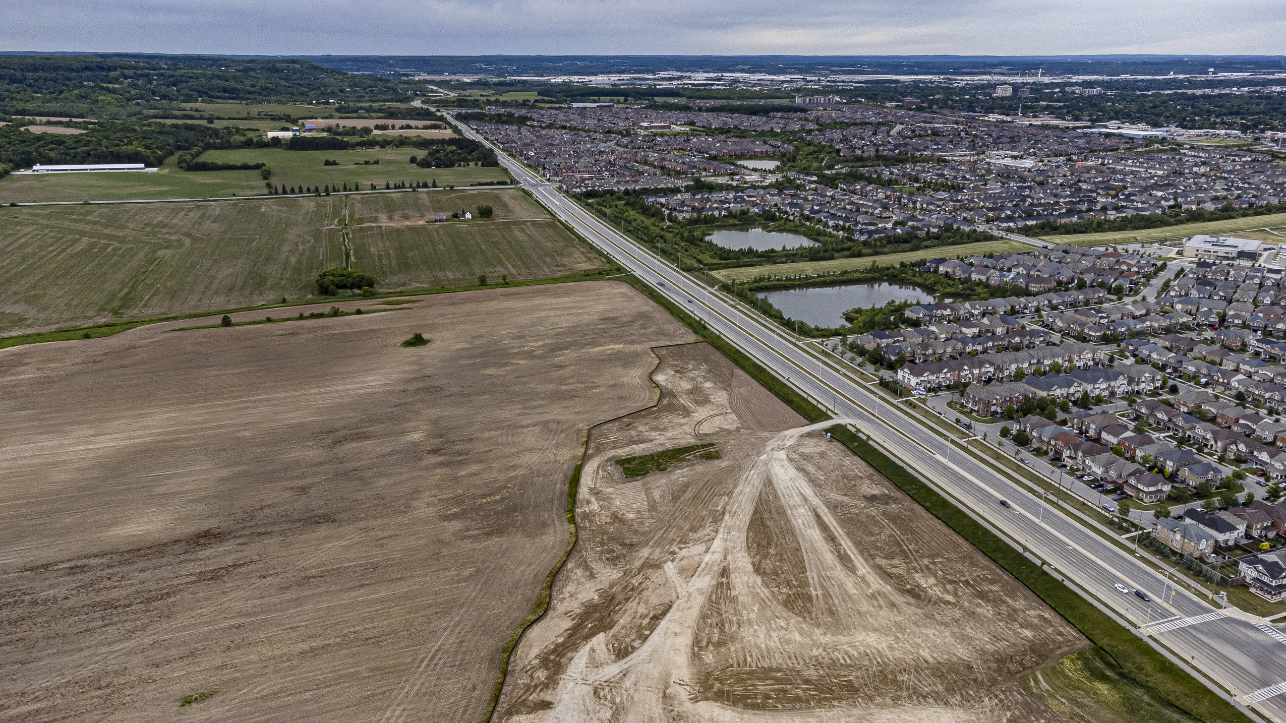 Ontario Greenbelt: a road forms the boundary between farm fields and suburbs