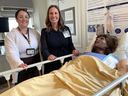 From left: Michelle Brosso, an inter professional learning specialist at Kingston Health Sciences Centre, and Heather Mackulin, KHSC's interim director of professional practice, are pictured with the mannequin Susie, who helps health-care professionals learn hands-on skills to give them more confidence in their jobs at Kingston's hospitals. They're pictured at Kingston General Hospital on Thursday, May 14, 2026.