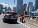 A delivery driver on an e-bike is stopped by Toronto Police on the Gardiner near Spadina.