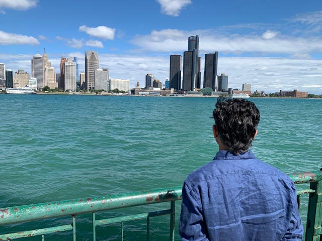 A person looks at Detroit skyline across Detroit River in Ontario