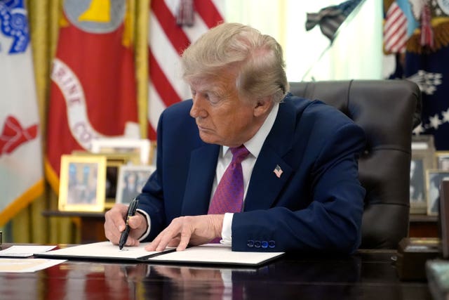 President Donald Trump signs an executive order in the Oval Office of the White House in Washington