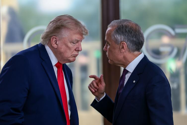 Two older white men in suits having a conversation