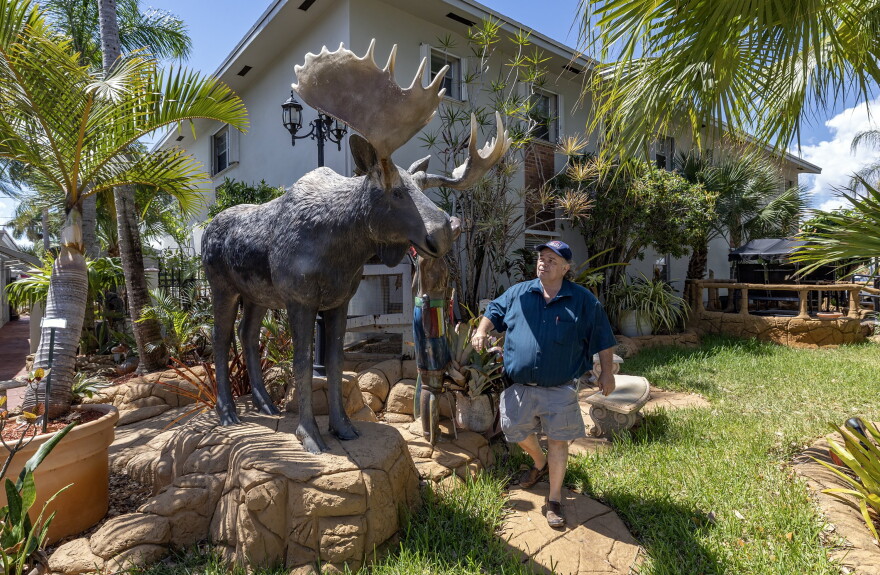 Clavet walks past a statue of a moose he brought from Canada and put on display at one of the Canadian-themed hotels and motels he owns.
