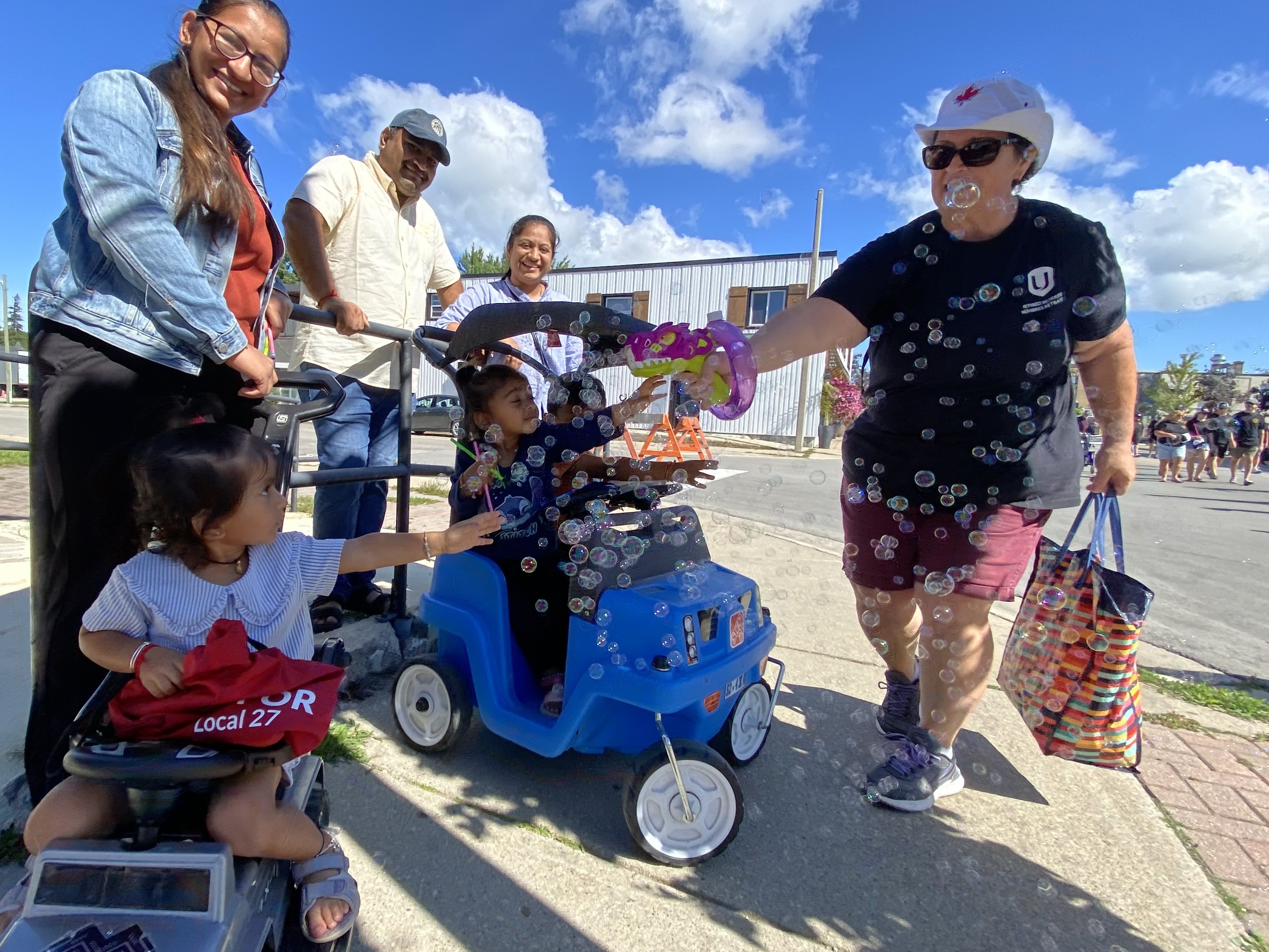 A woman blows bubbles from a toy gun and kids try to touch them at the annual Labour Day Parade in Port Elgin Monday.
