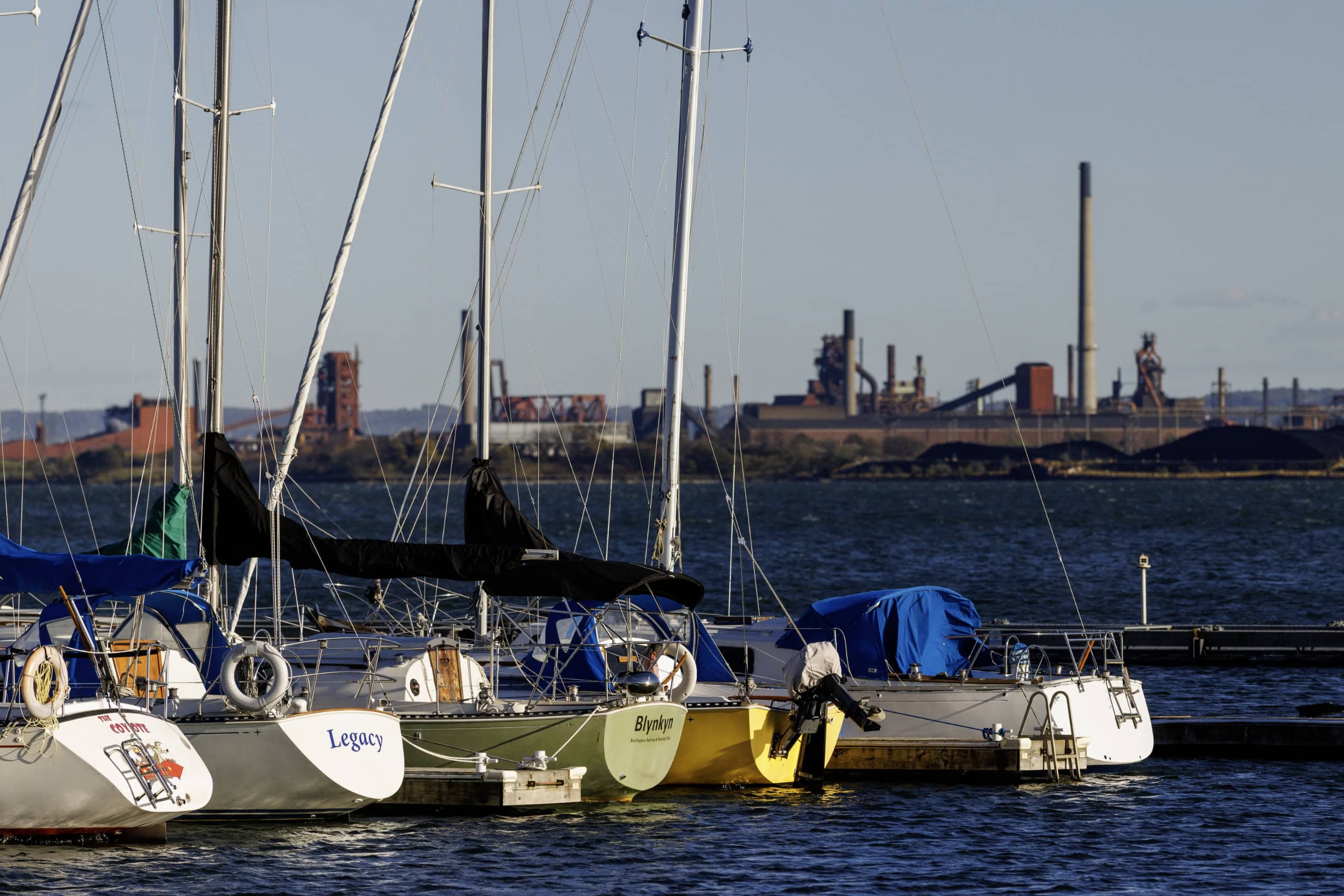 Sailboats docked at a marina in Burlington, Ont., with the Arcelor Mittal Dofasco steel plant in the background across Hamilton Harbour.