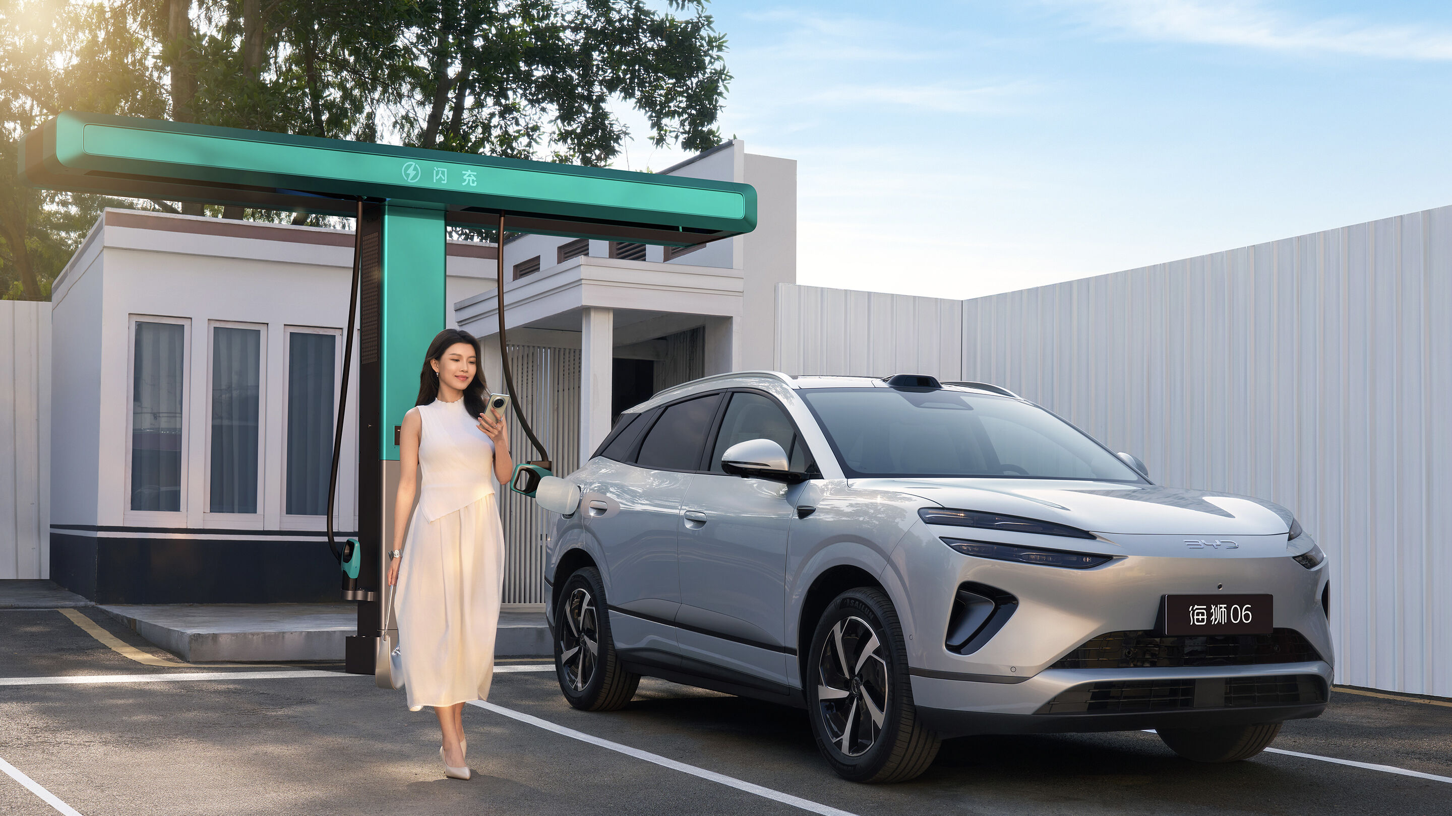 Silver %2026% BYD Sealion %(060)% EV linked-up against flash charger while woman stands beside it
